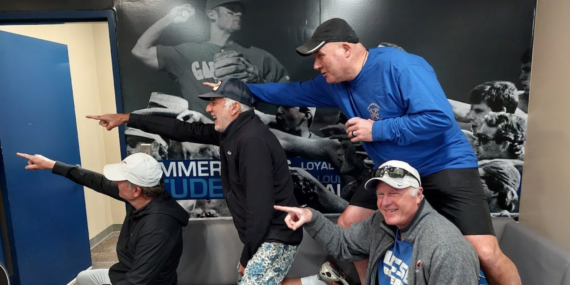 Group of four men pointing