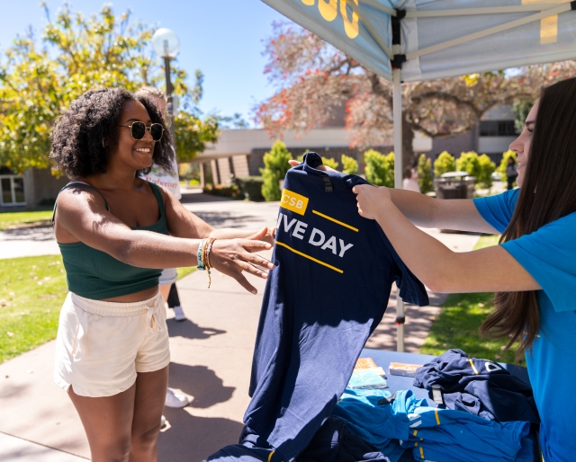 Woman receiving Give Day Shirt