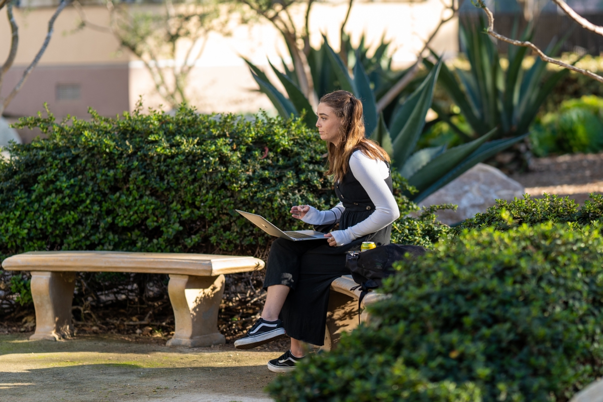 Student on laptop sitting outside